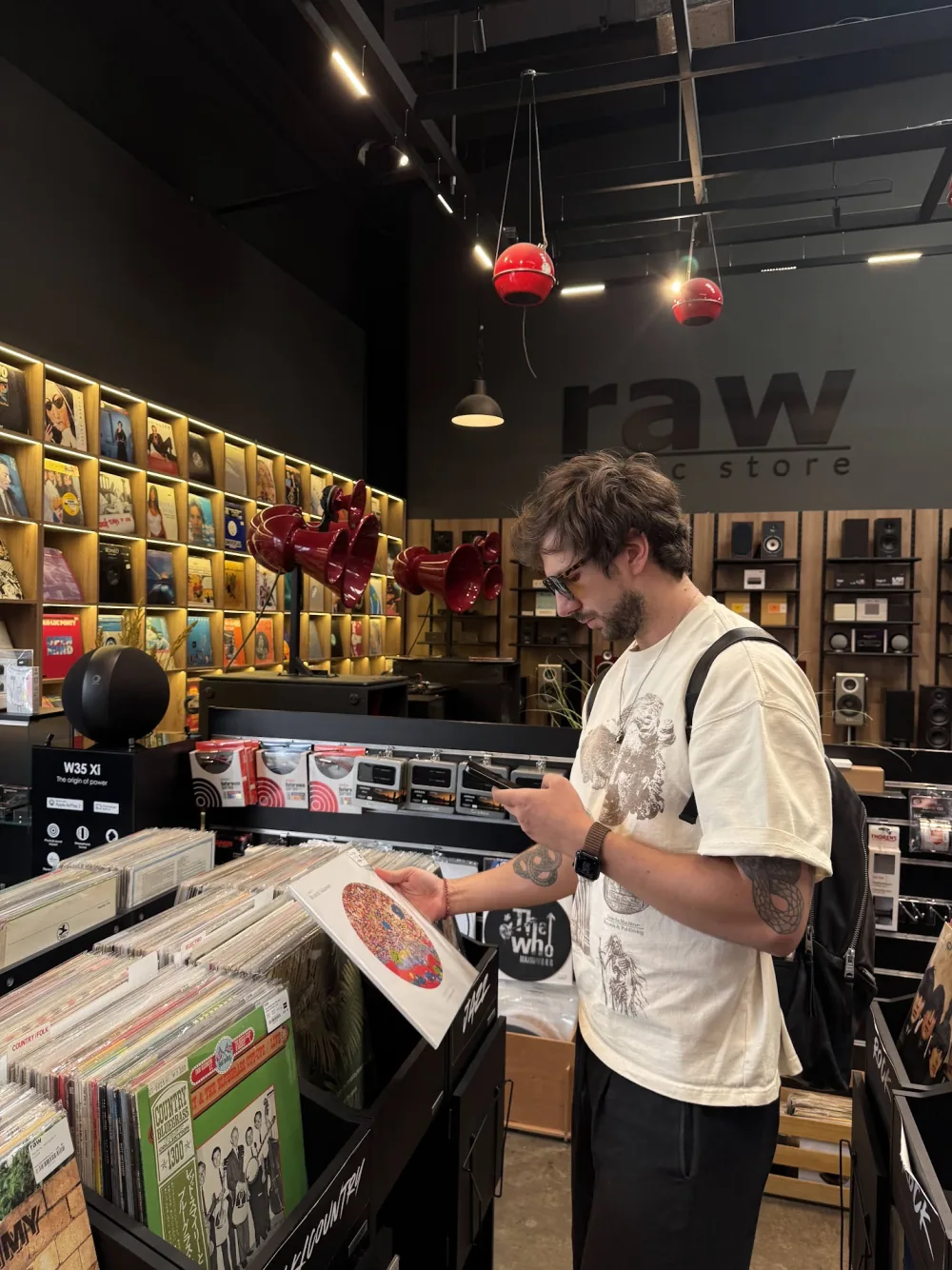 A person using Plastic while holding a record in a shop